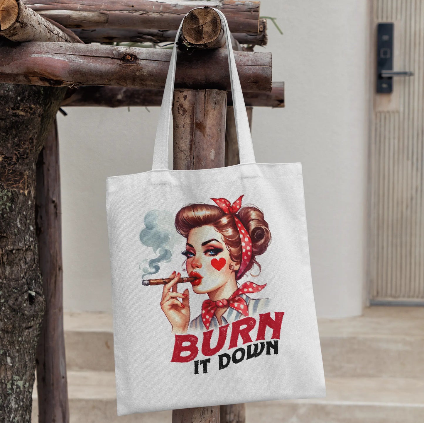 White tote bag with a bold retro pin-up girl smoking a cigar and red text that says:
"BURN IT DOWN"