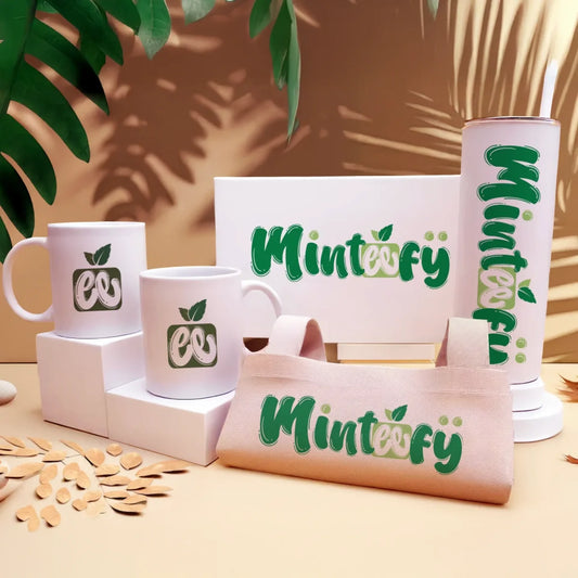 Minteefy branded drinkware, tote, and box set in green and white on a beige tropical background.