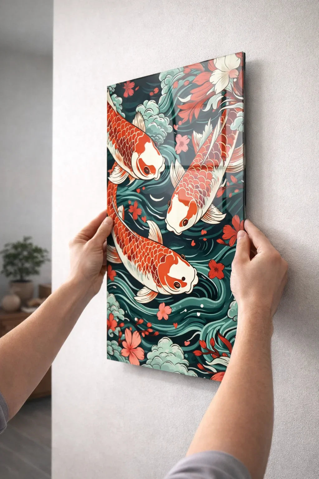 Glass wall art featuring koi fish, floral patterns, and swirling water being hung on a wall